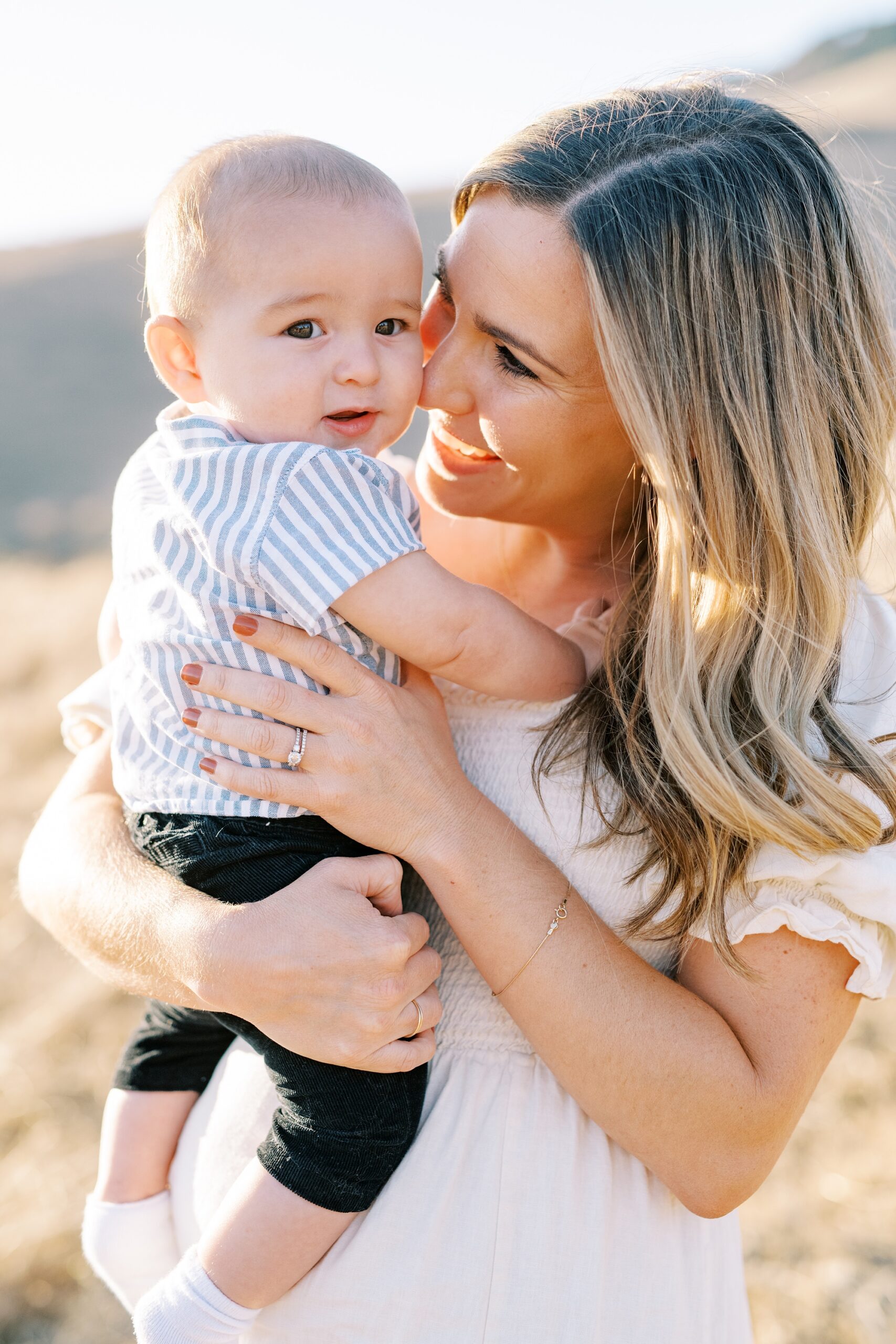Mama holding baby with blue and white striped jumper at Bishop Peak family photos by San Luis Obispo Family Photographer Austyn Elizabeth Photography 
