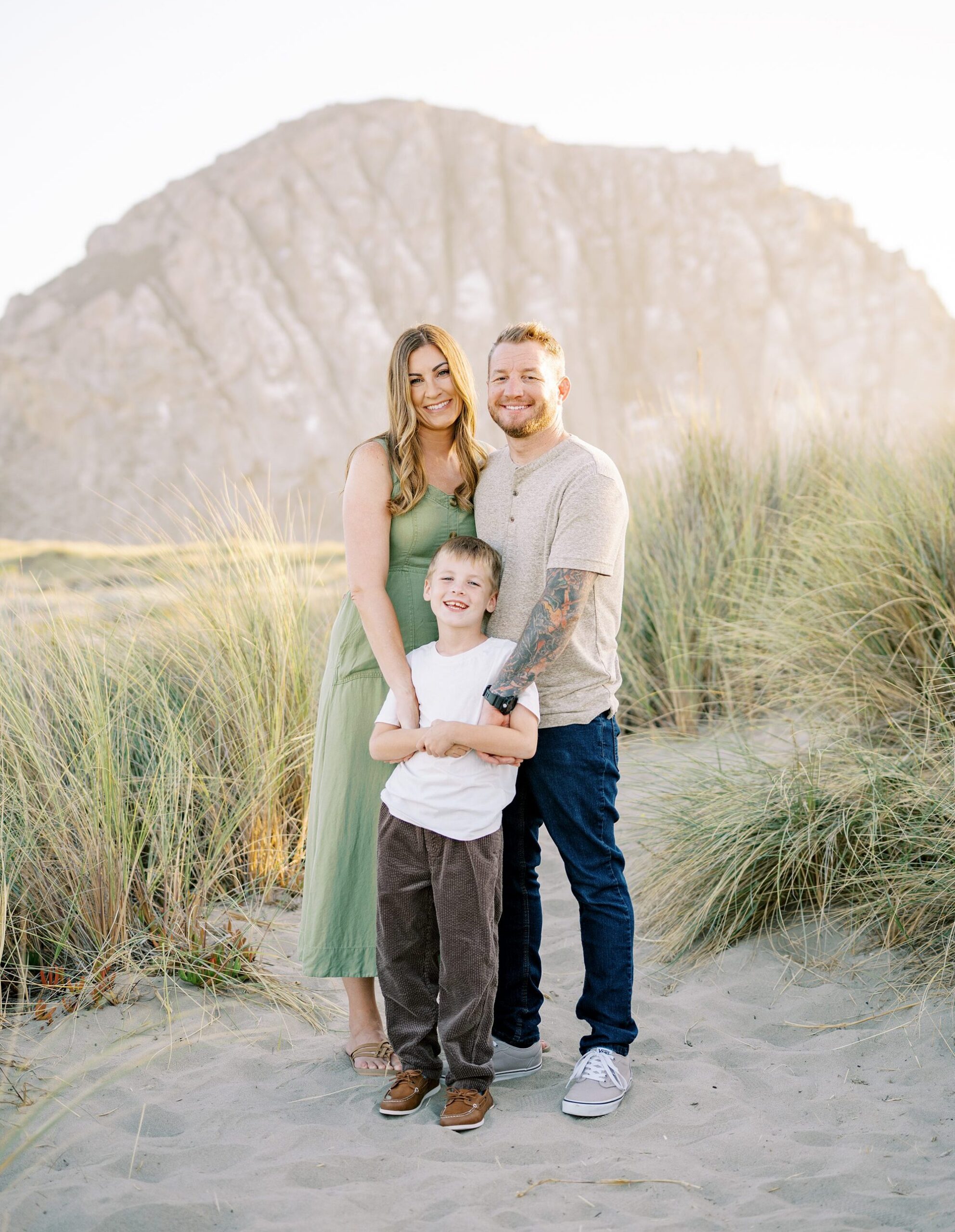 A family of three in front of Morro Rock at Morro Bay Dunes by Morro Rock Family Photographer Austyn Elizabeth Photography