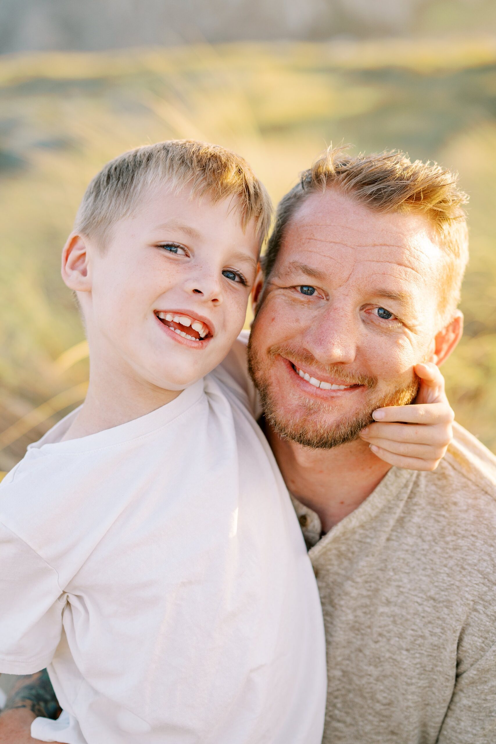 Son and ad smile at camera by Morro Bay Family Photographer Austyn Elizabeth Photography