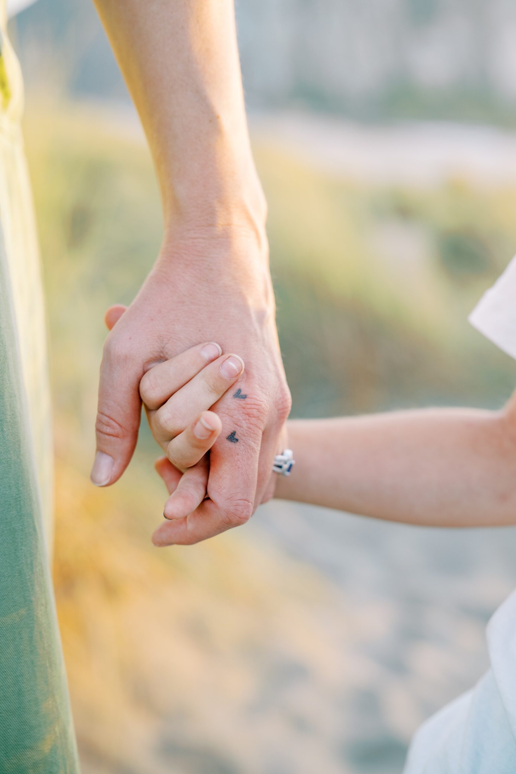 Mom has heart tattoos where their son's fingers rest on her hand when they hand hold by Morro Bay Family Photographer Austyn Elizabeth Photography